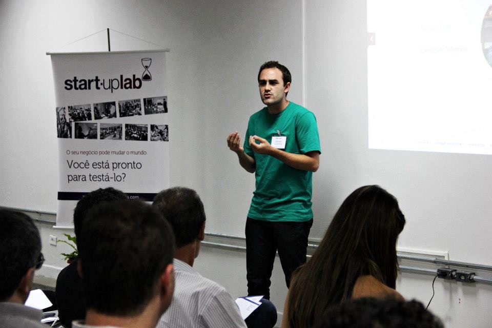 Dan Queirolo de camiseta verde, em pé, dando uma palestra no Startup Lab
